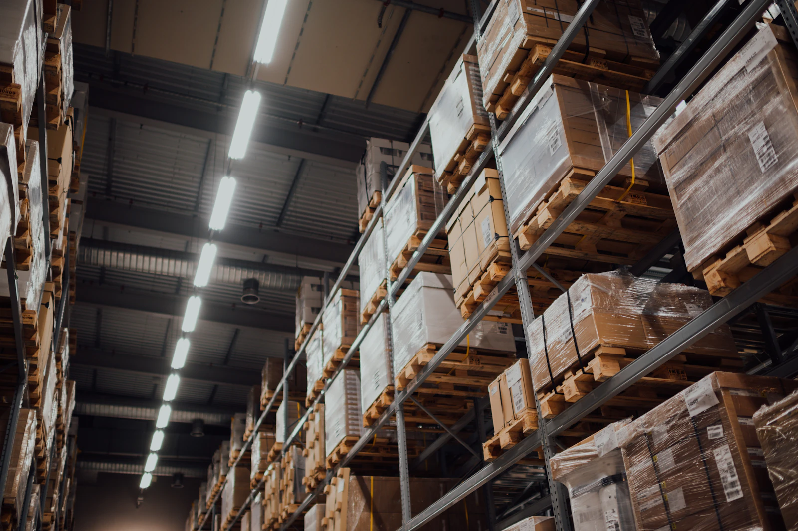 Cardboard boxes stacked on white metal warehouse racking